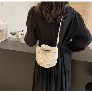 Détails de texture du sac tressé fait main blanc cassé avec poignées et bandoulière