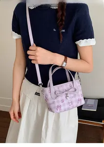 Detailed view of lavender plaid bucket bag with cute bear prints and bow charm on model