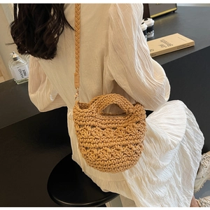 Détail du motif ajouré tissé main sur sac en paille kaki avec bandoulière large