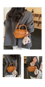 Détail du sac Boston vintage marron avec breloque lapin en peluche et boucles argentées