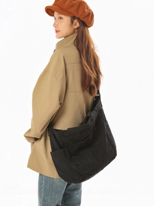 Large black canvas crossbody bag shown on a model with a minimalist retro casual design