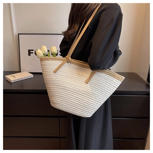 Detail of minimalist woven tote bag with brown contrast straps and tulip decoration