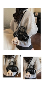 Détail du sac bowling en cuir noir brillant avec breloque lapin en peluche et poignées