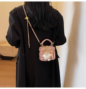 Pink tweed mini crossbody bag detail with cute white plush charm and gold chain strap