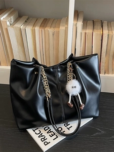 Fashionable black faux leather tote bag with gold chain strap and cute plush charm pendant