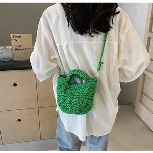 Vue détaillée de la texture tissée évidée verte et de la bandoulière en crochet du sac