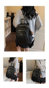 Détails du sac à dos en cuir noir avec sangle géométrique et porte-clé en peluche