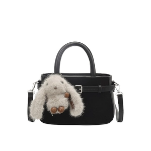 Elegant black matte top-handle bag with a cute plush bunny charm and silver buckle