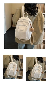 Détail d'un sac à dos blanc en similicuir grainé avec un porte-clé pompon en peluche