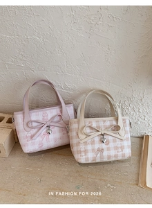 Detail of pink and beige plaid bucket bags with cartoon cat prints and metal heart charms