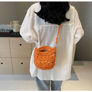 Détail du sac au crochet orange avec texture ajourée et boucle métallique sur le côté