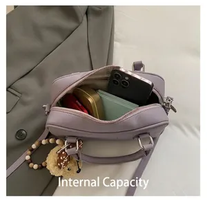 Internal storage detail of purple leather handbag showing phone, wallet, and cosmetics