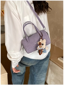 Violet rectangular tote bag with white stitching and a cute bear plush charm on a model