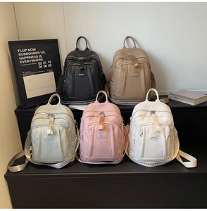 Détail de sacs à dos décontractés multicolores en similicuir avec fermeture et logo