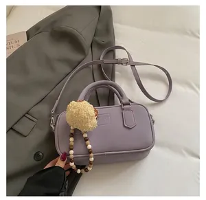 Close-up of lavender bowling bag with matte texture and cute plush charm detail