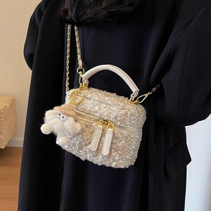 Chic tweed chain crossbody bag in beige with fuzzy plush charm on a black coat model