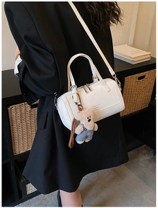 Dettaglio della borsa Boston bianca con ciondolo a orsetto e scritta Fashion & BAGS