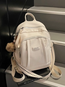 Sac à dos à la mode en similicuir beige avec breloque en peluche sur socle épuré
