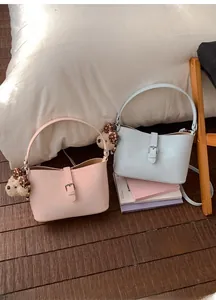 Rosa und blaue Hobo-Taschen mit Bärenanhängern auf einem warmen Holzhintergrund