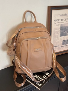Sac à dos vintage en cuir marron avec logo argenté et bandoulière géométrique