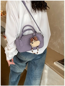 Détail du sac bandoulière violet au fini mat avec une jolie breloque ours en peluche