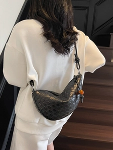 Black woven crescent hobo bag with a stylish amber bead and knot strap detail
