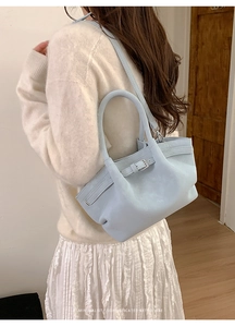 Primer plano de bolso cubo de cuero azul claro con hebilla de plata en una modelo