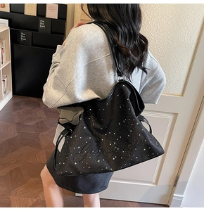 Détail du sac cabas noir avec motifs d'étoiles blanches et broderie élégante