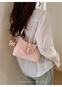 Detail der rosa Leder-Schultertasche mit süßem Plüschhund-Anhänger und Silberschnalle