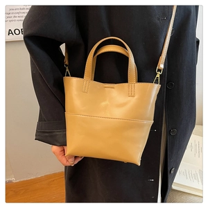 Detail of khaki PU leather tote bag with reinforced handles and gold metal buckles