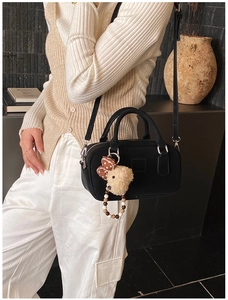 Détail du sac bowling noir avec pendentif ours en peluche et décoration perlée