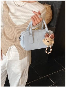 Détail du sac Boston bleu clair avec gaufrage GOIN RON et breloque ours en peluche