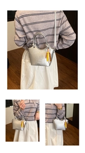 Detailsicht der silbernen Metallic-Eimertasche mit Perlenanhänger und Schultergurt