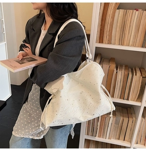 Détail du grand sac cabas blanc avec motifs d'étoiles argentées et cordon de serrage