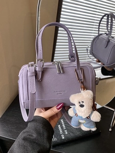 Fashionable purple Boston handbag with cute teddy bear charm and adjustable shoulder strap