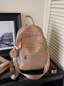 Fashionable brown large capacity backpack with geometric straps and plush ball charm