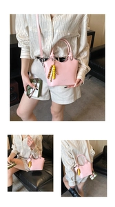 Detailansicht der rosa Beuteltasche mit Perlenanhänger und Knotengriff-Design