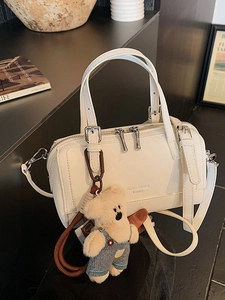 Elegant off-white Boston leather handbag with shoulder strap and cute bear charm