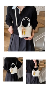 Detailansicht einer weißen Eimertasche mit Perlenquasten und verstellbarem Schultergurt