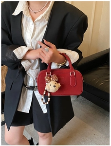 Détail du sac bowling rouge avec pendentif ours en peluche et nœud à pois