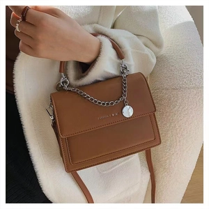 Détail du sac bandoulière en cuir marron avec chaîne argentée et gaufrage FASHION & BAG