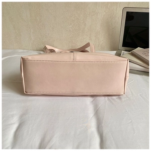 Flat base detail of large beige tote bag showing reinforced stitching and wide capacity