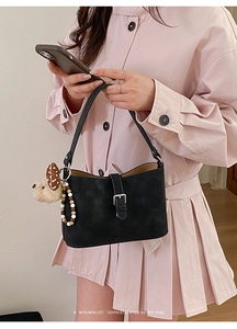 Schwarze Retro-Achseltasche mit Welpen-Plüschanhänger und bunter Perlenkette im Detail