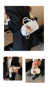 Détail du sac bowling en cuir PU blanc avec un joli pendentif ours et une bandoulière amovible