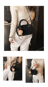 Détail du sac bowling noir avec bandoulière et breloque en peluche en forme d'ours