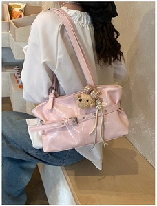 Pink glossy shoulder bag with silver buckle, tassel detail, and a cute brown plush bear