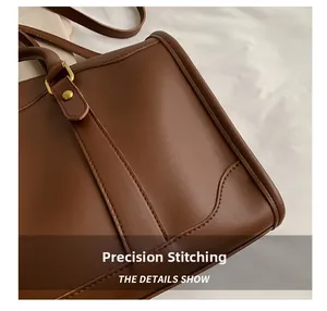 Detail view of precise computerized stitching and brass hardware on dark brown leather bag