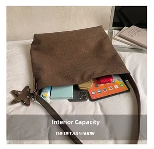 Detail showing internal capacity of the brown woven tote with star charm and accessories