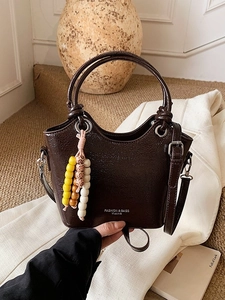 Sac seau marron foncé en cuir ciré brillant avec poignées rondes et charme de perles