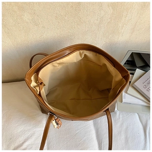 Brown large capacity leather tote bag with top zipper and bead pendant accessory